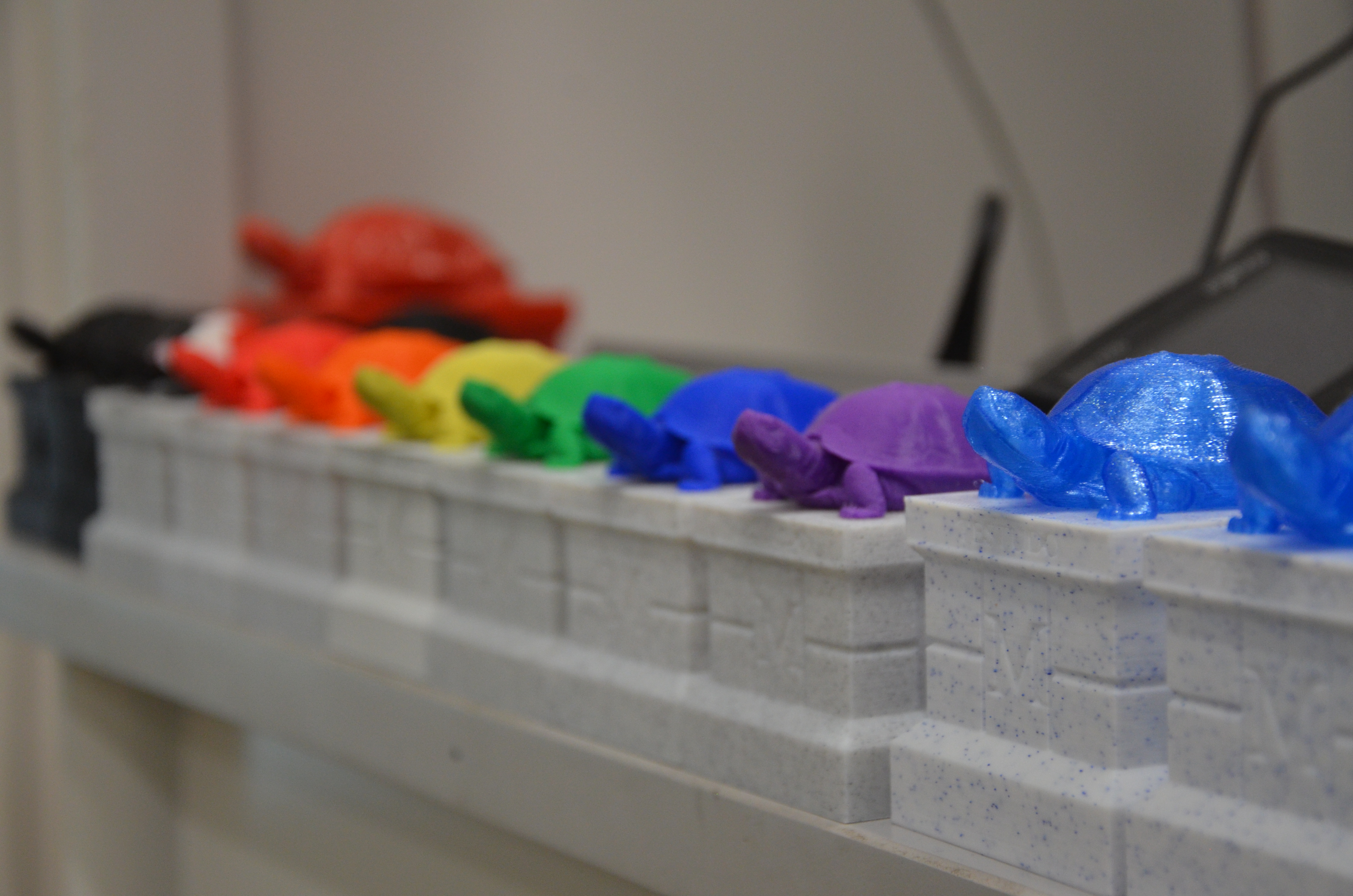 3-D printed testudo statues arranges in rainbow order