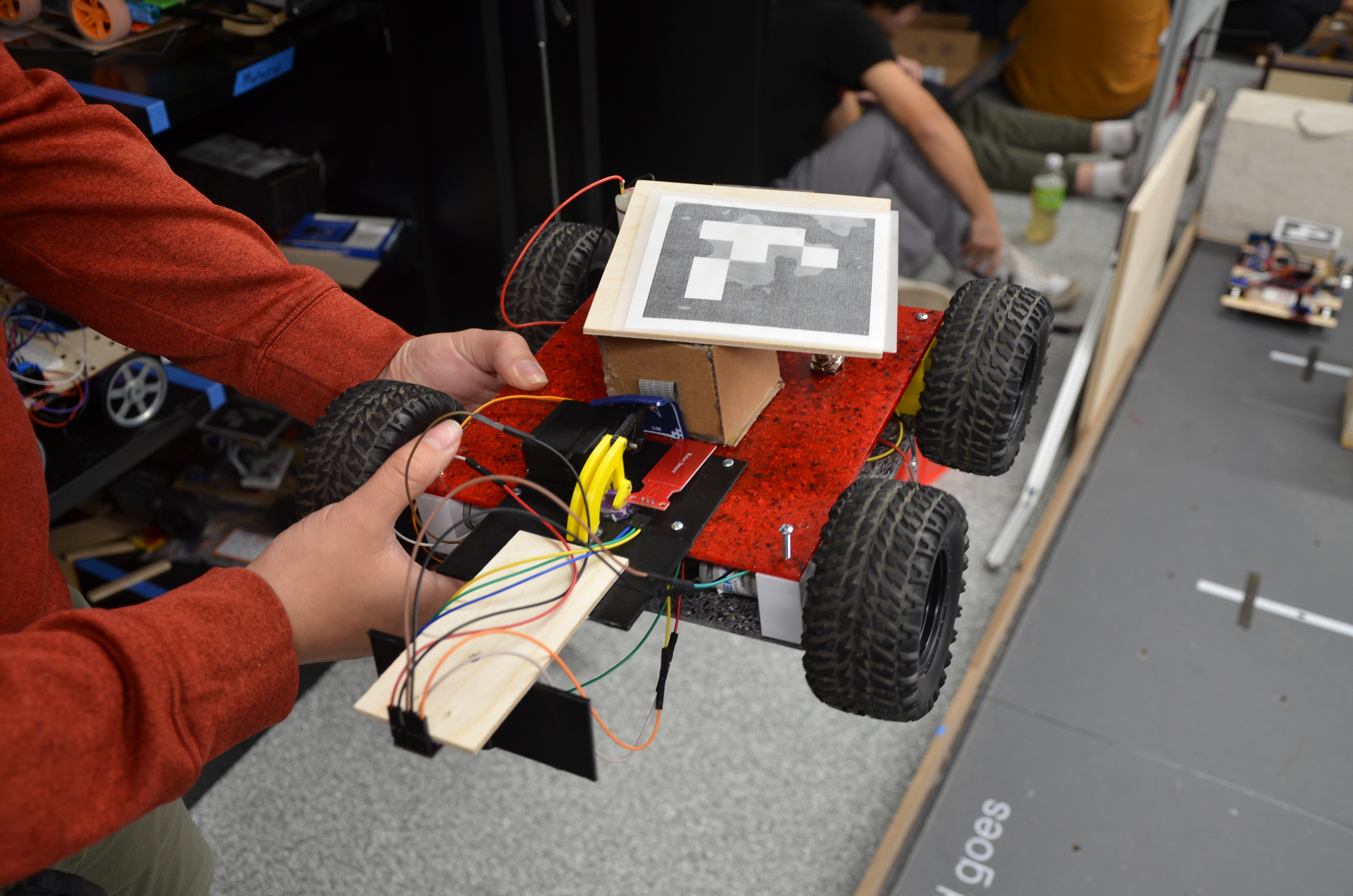 Student-made rover with wires, wheels, and a PLA sheet middle.