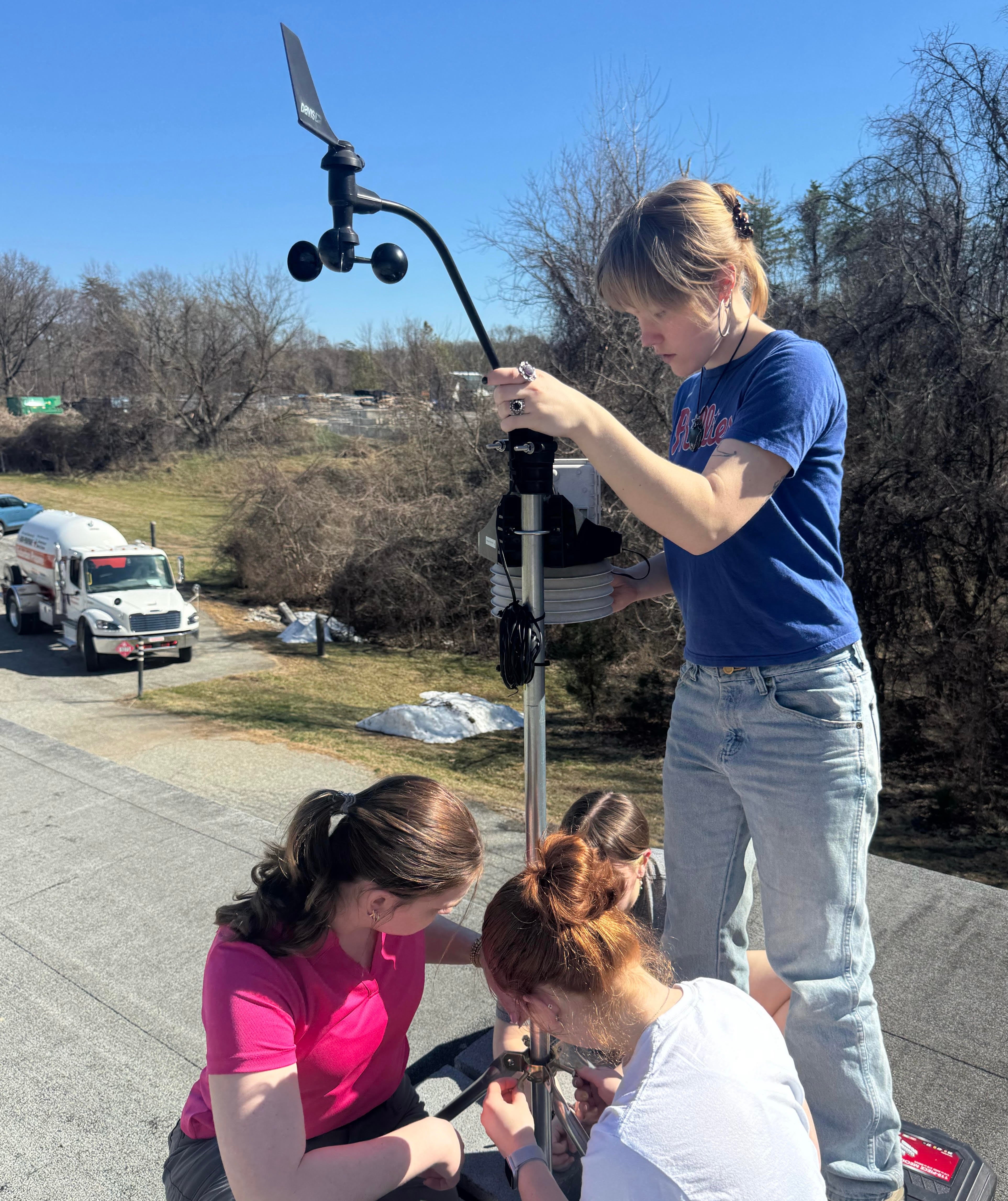 Four students assemble a Mesoterps' weather station.