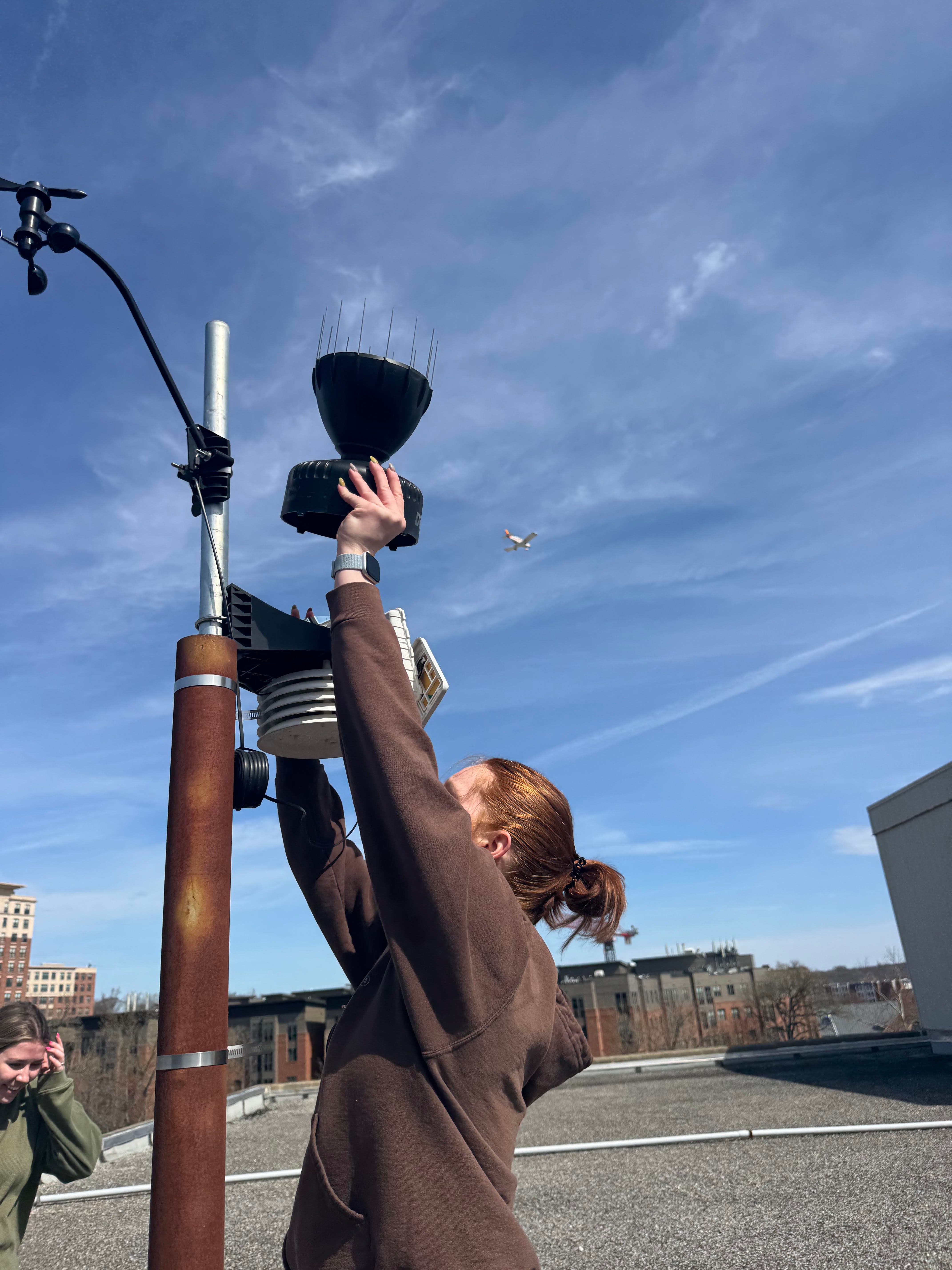 Mesoterps' Student Project Manager helps set up a weather station.