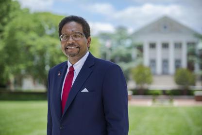 President Pines standing in front of the main administrative building on campus