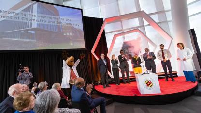 Campus leaders clap on stage during Chemistry Building Dedication.