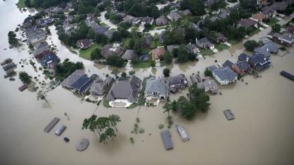 Photo by Win McNamee/Getty Images - Aerial view of homes and streets submerged in floodwater during a severe flooding event.