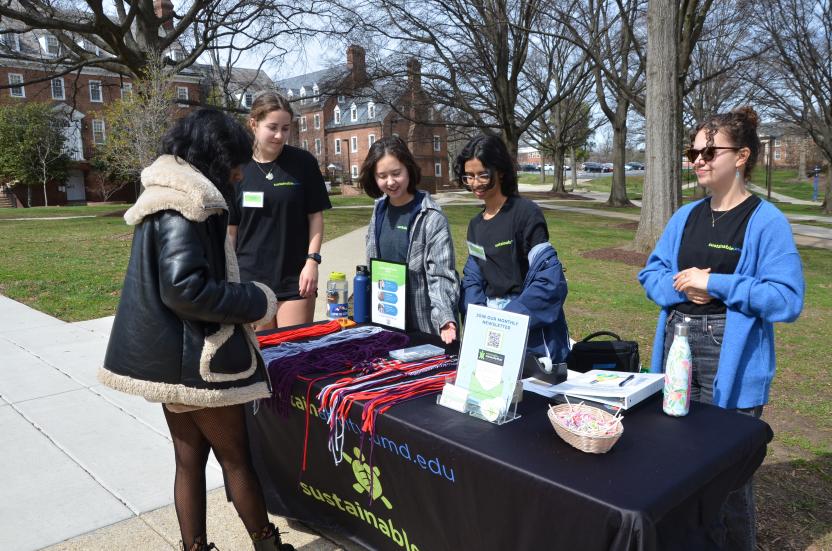 Students interacting at the OS table making keychains