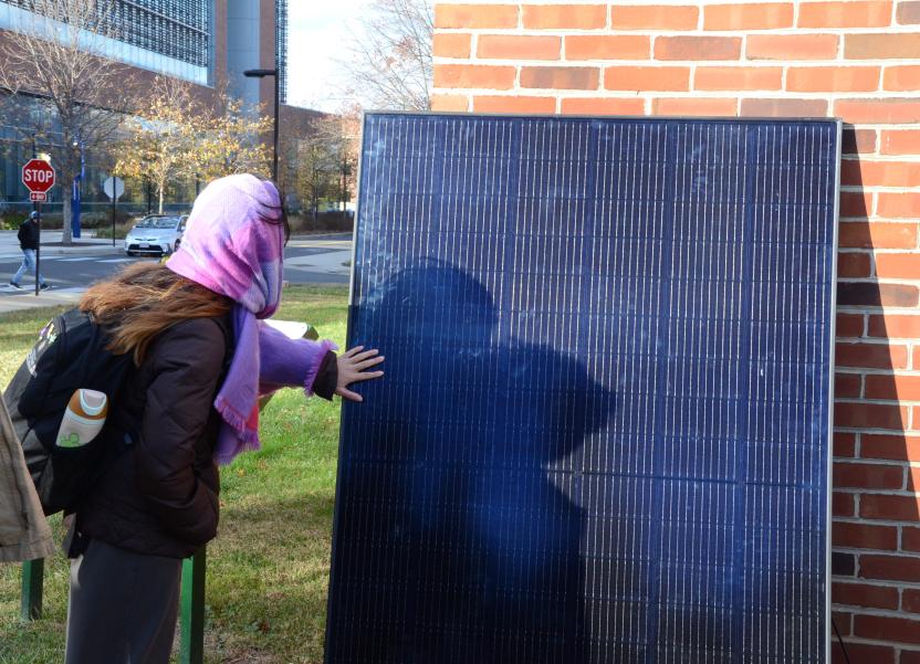 Student reaches out to examine a solar panel