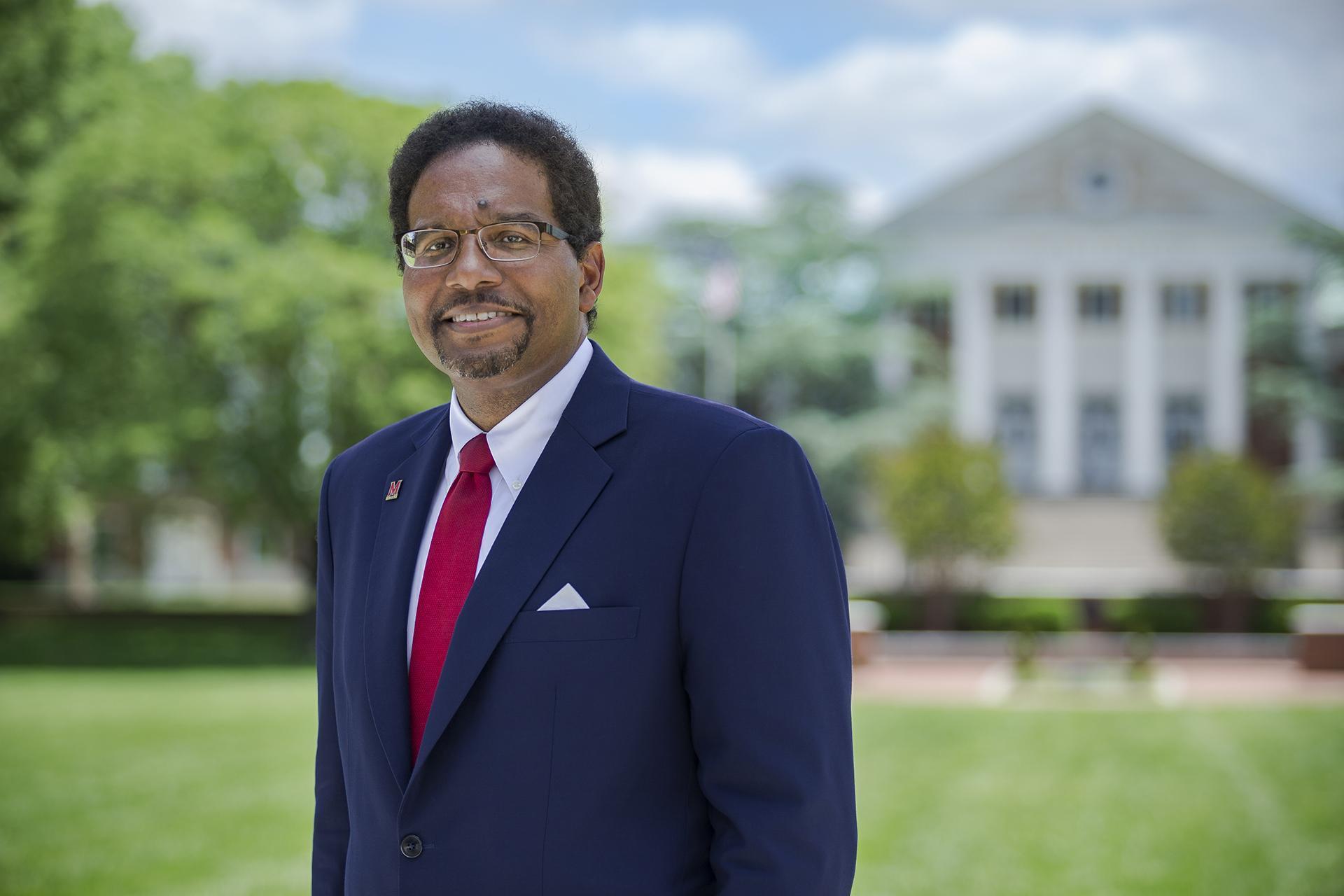 President Pines standing in front of the main administrative building on campus