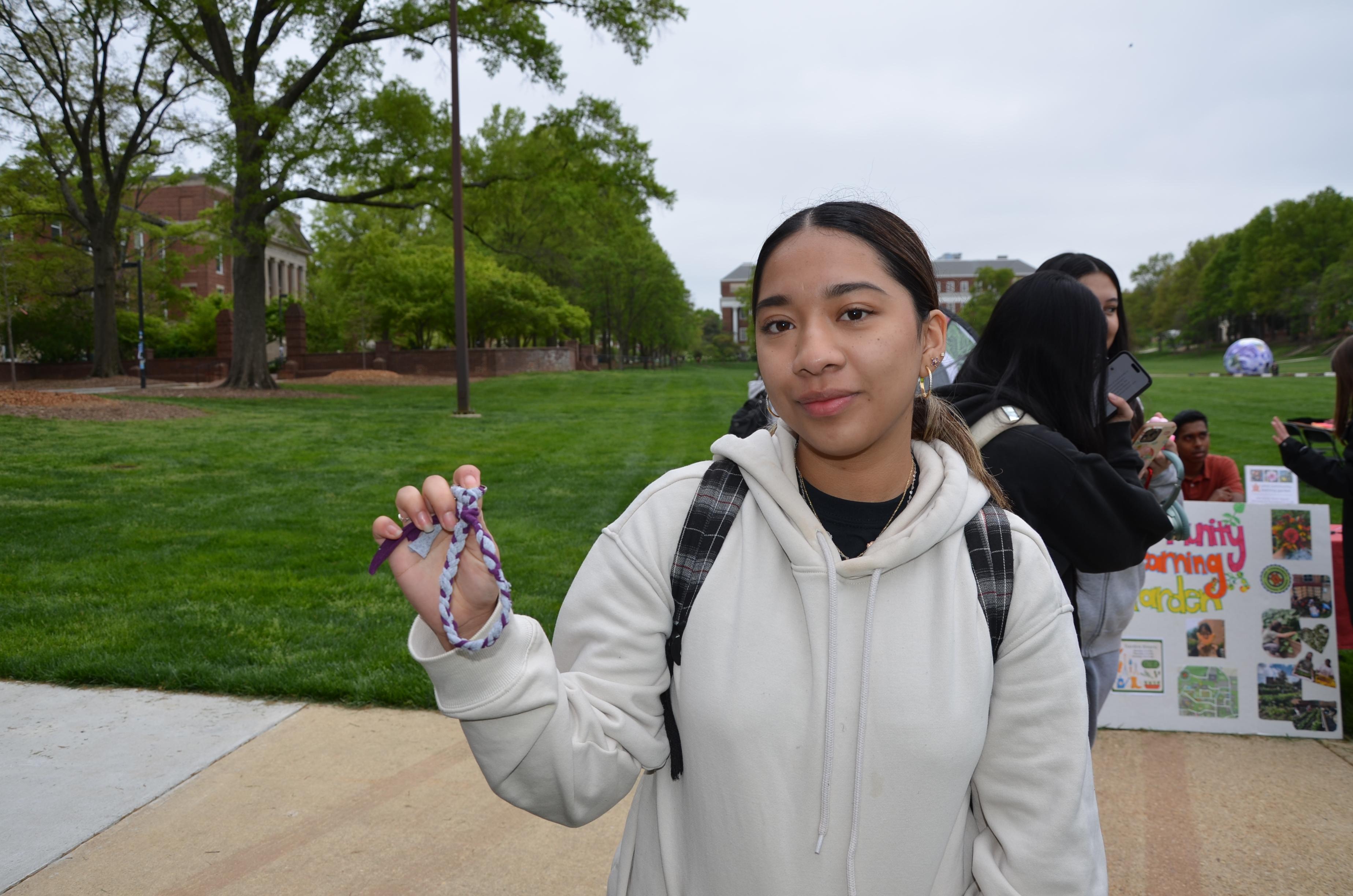 Student posing with the upcycled keychain they made