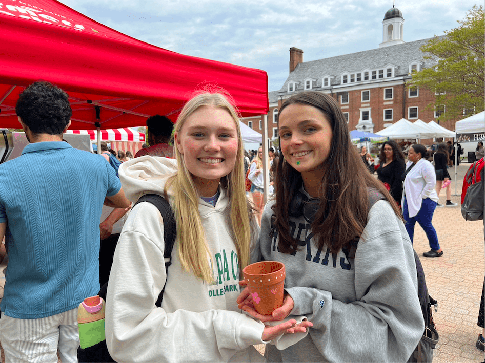 Two girls smiling holding a planter