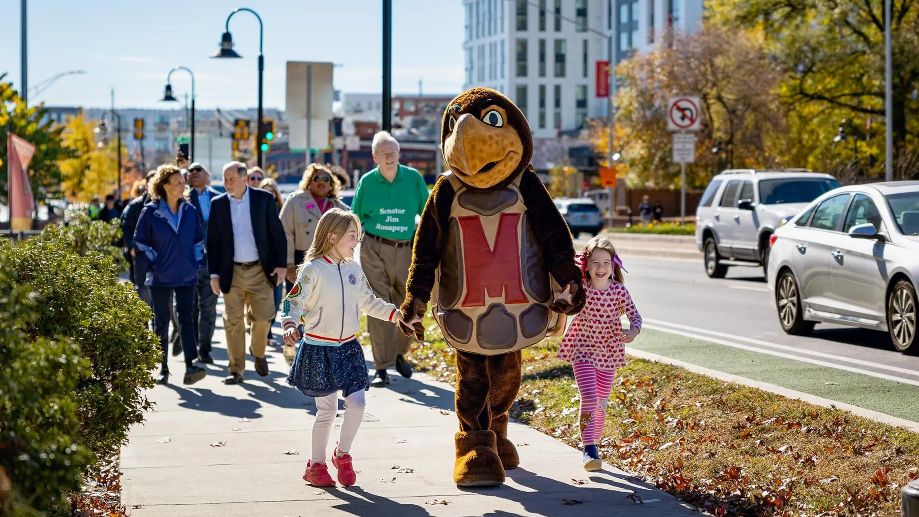 parade down street including testudo mascot and kids