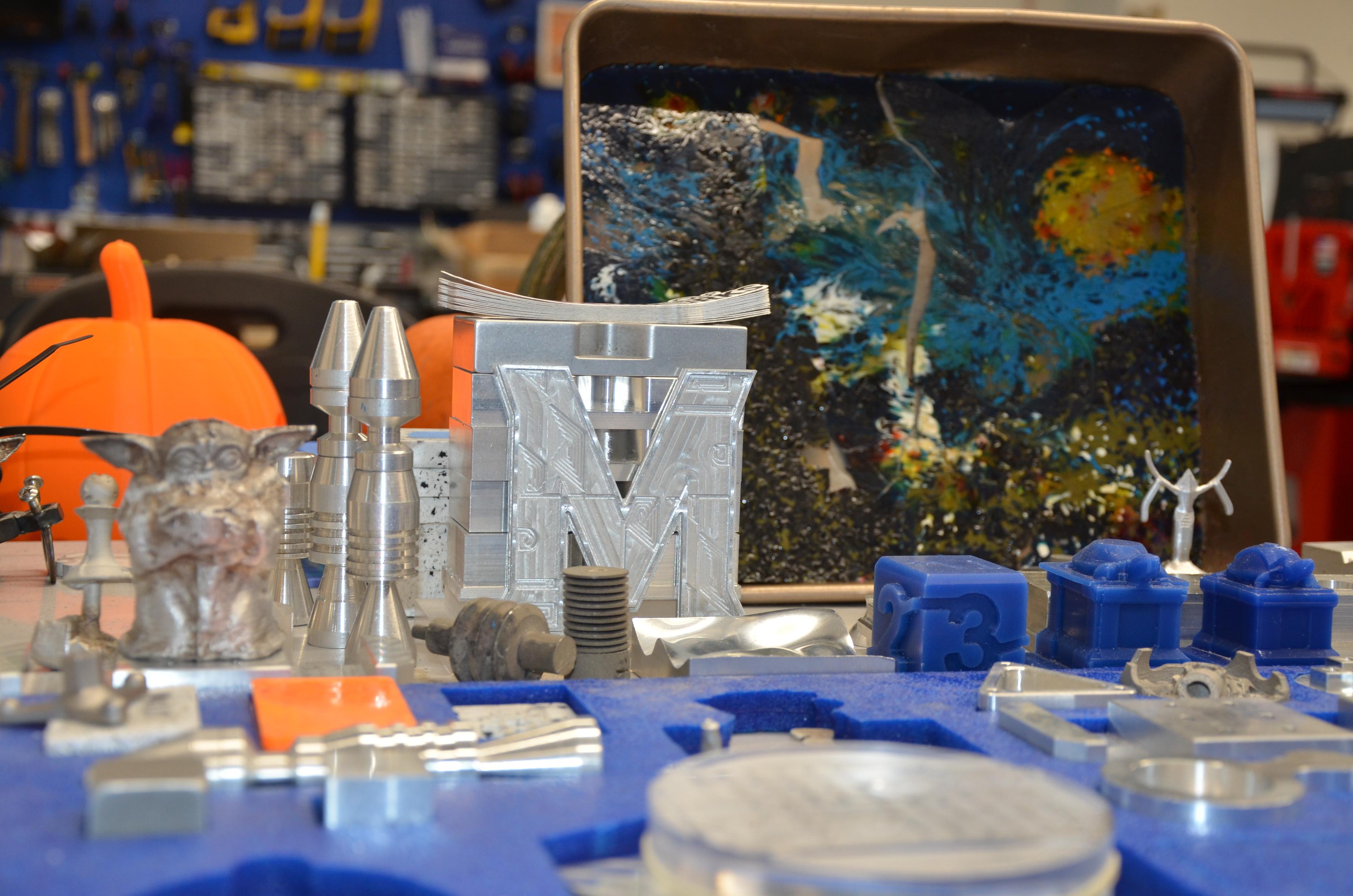 Mixture of metal and plastic trinkets include a metal M and mini blue, plastic Testudo statue molds