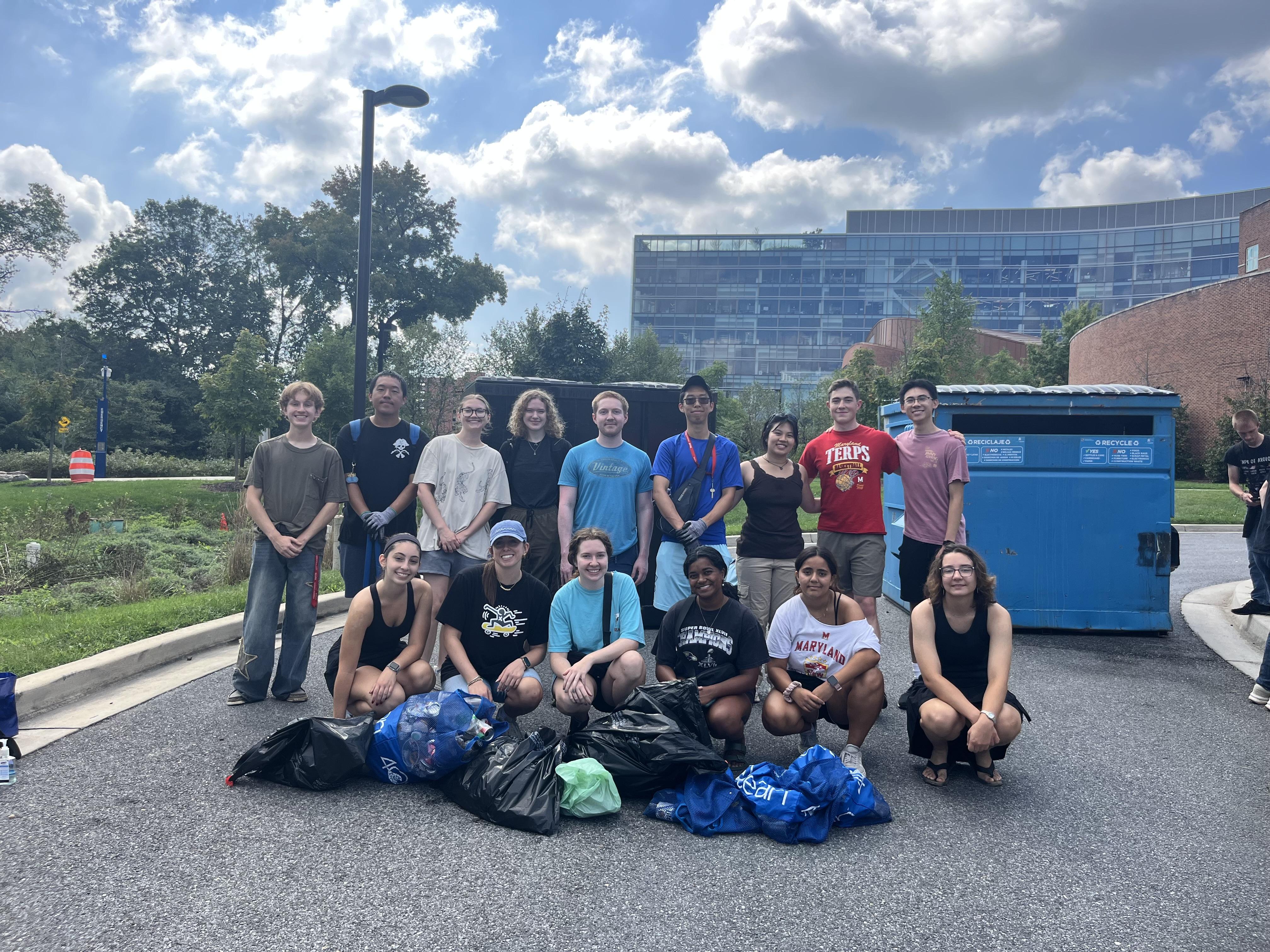 Students in the Sustainable Ocean Alliance crouch in front of bags of litter, collected in their weekly cleanup.