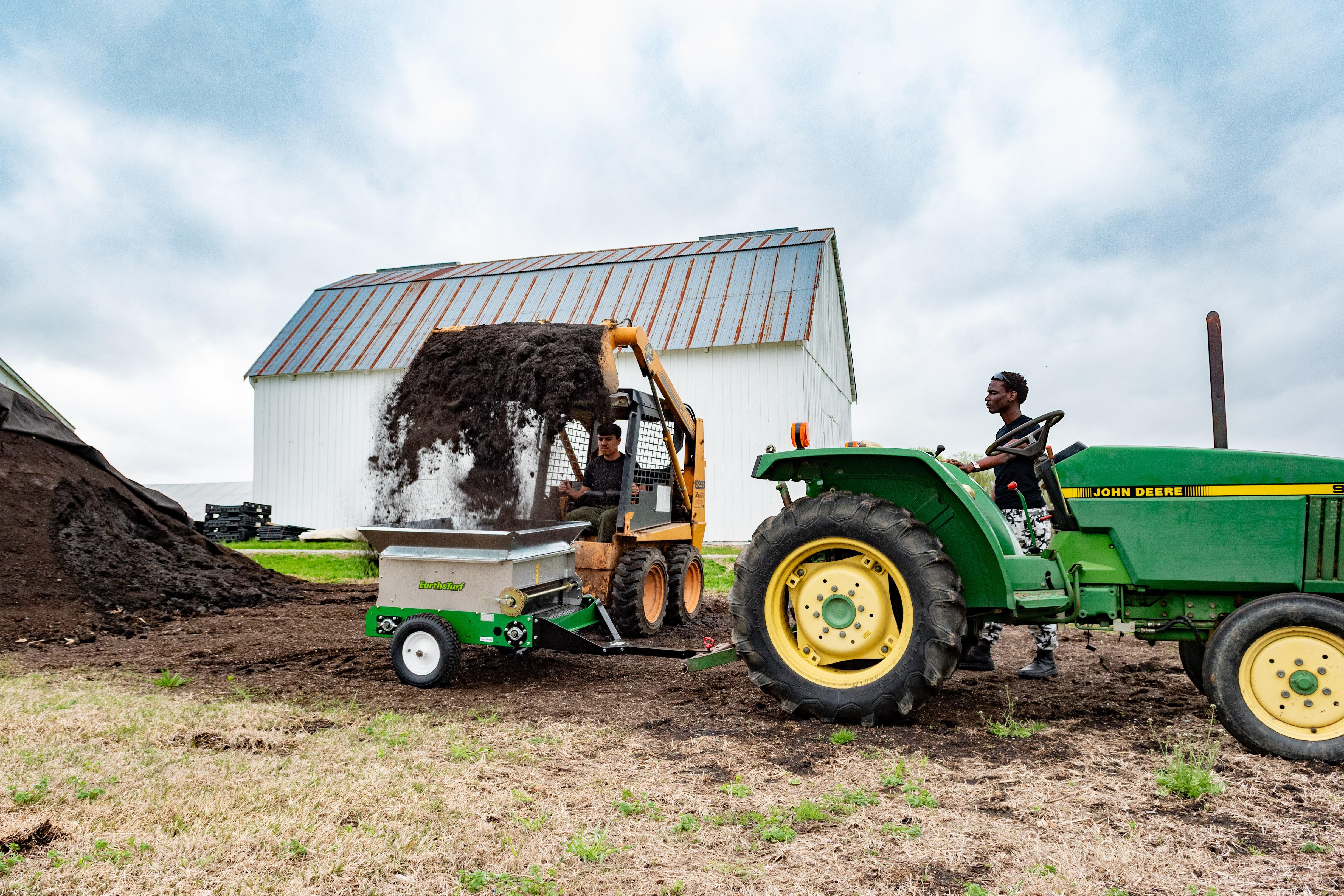 Students use a compost spreader at Terp Farm