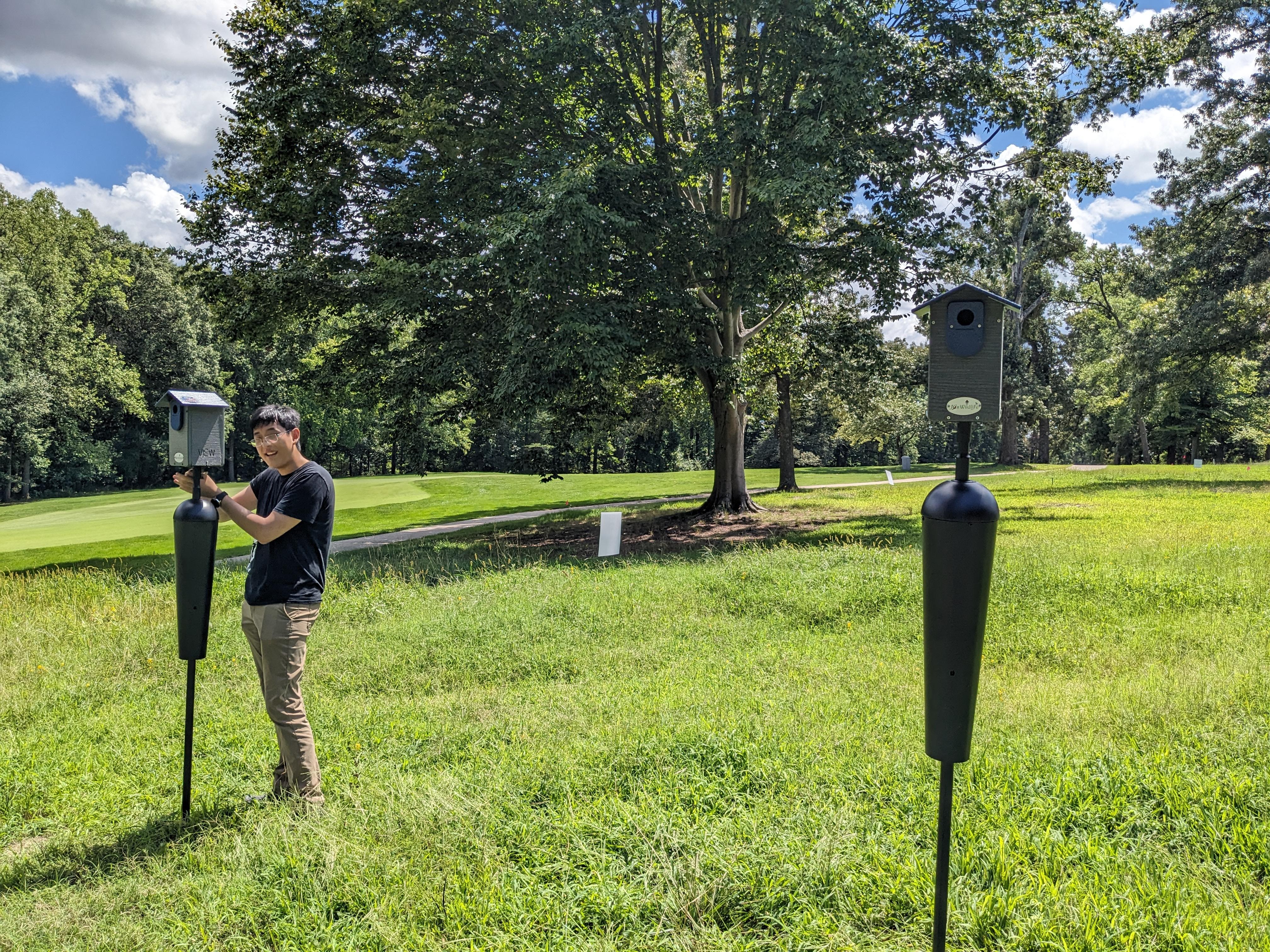 A student sets up a birdhouse at the UMD Golf Course