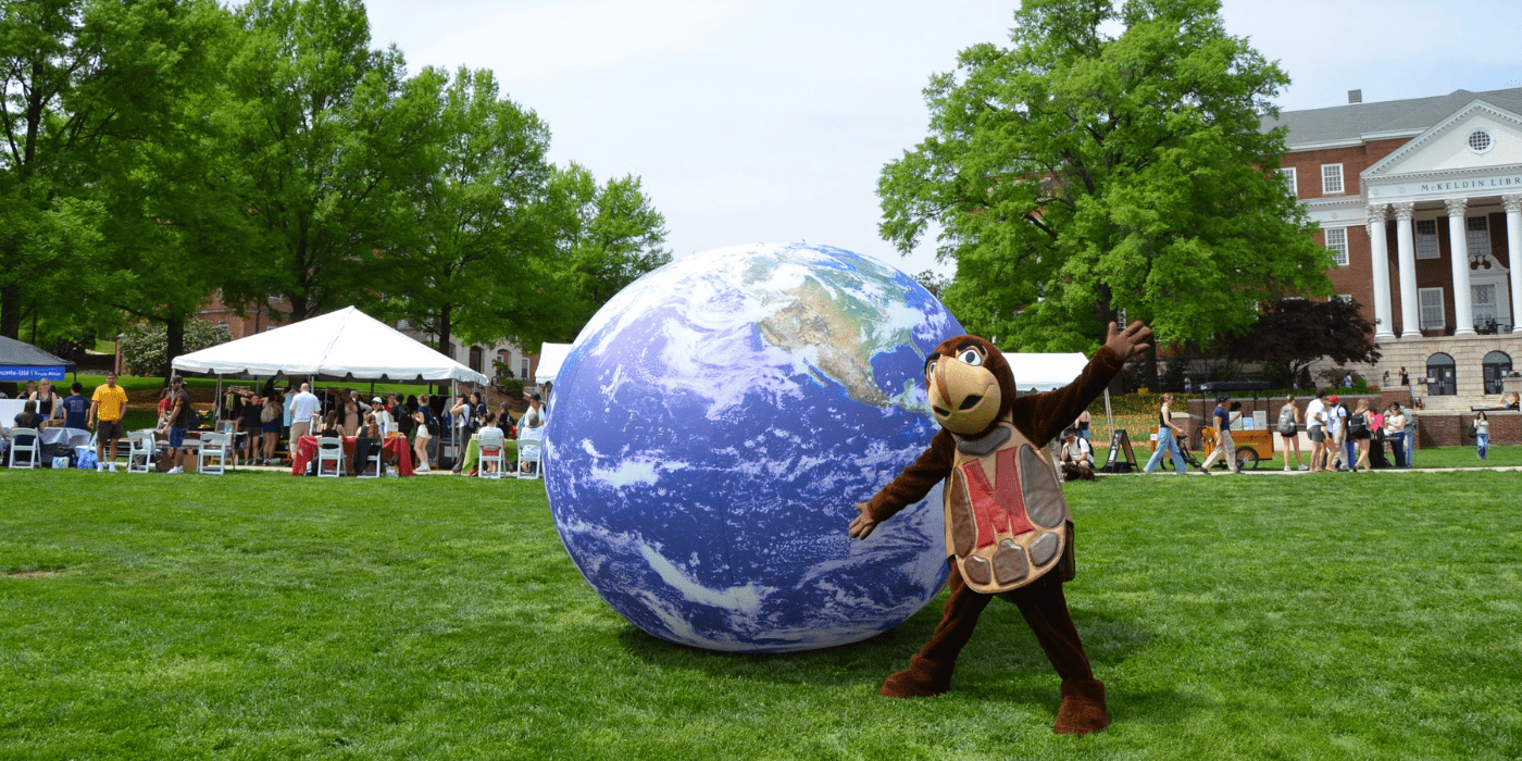 Testudo poses on McKeldin mall next to a large inflatable Earth.