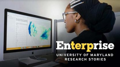 Person analyzing data visualizations on a computer screen in a research or office setting.