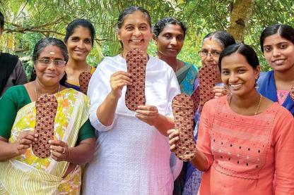 Group of women smiling and holding woven products made from natural fibers.