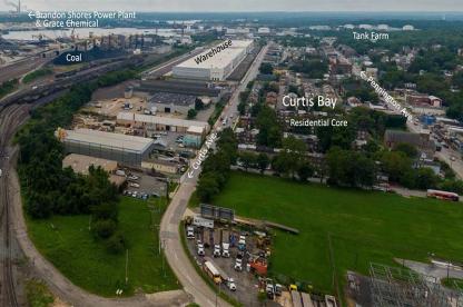 Aerial view of the Curtis Bay industrial area with warehouses and nearby residential neighborhood in Baltimore.