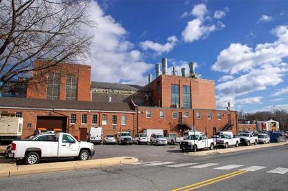 University of Maryland campus energy plant building with utility equipment and parked vehicles.